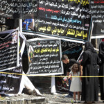 Iraqis Gather On Thursday Next To Banners Of Condolences At A Memorial