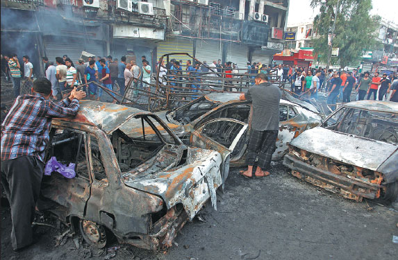 People Inspect The Site Of A Suicide Car Bombing In The Karrada 